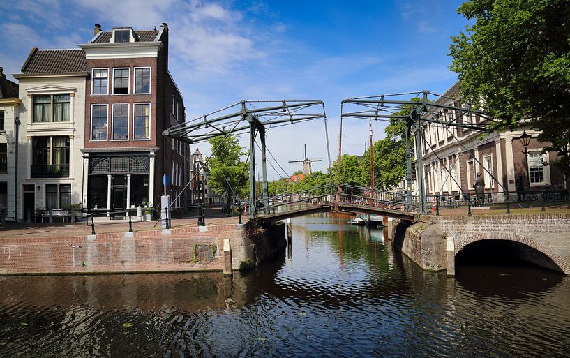 Historical drawbridge across a canal and a windmill in Schiedam, Holland by Jan Kranendonk