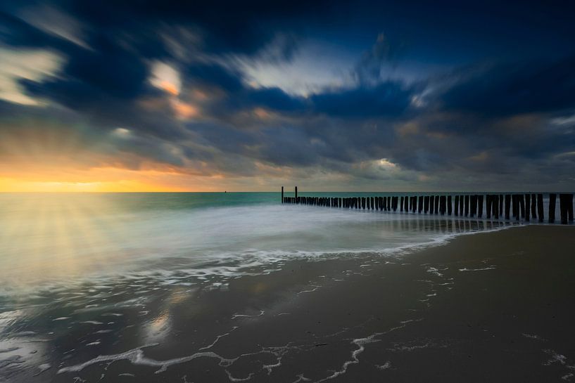 Nuages hollandais et brise-lames typiques de poteaux en bois le long de la côte zélandaise par gaps photography
