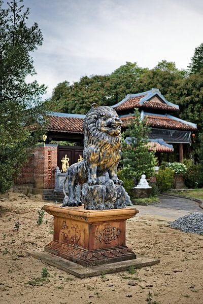 Carved lion watching over a sacred pagoda by Frank Photos