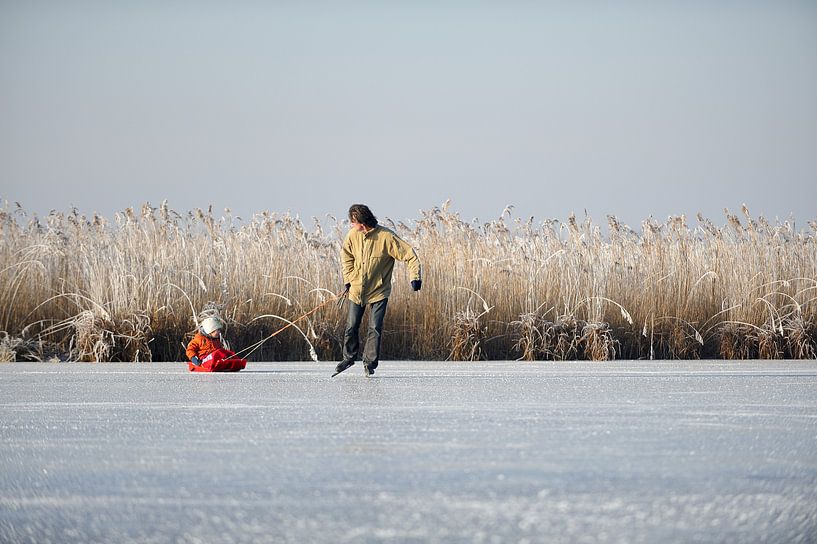 Schaatsende vader met kind op slee van Merijn van der Vliet
