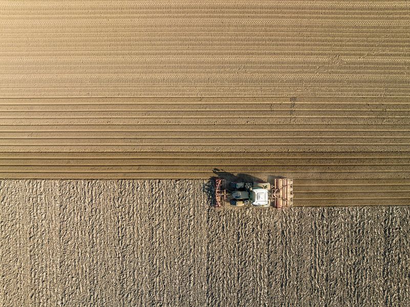 Tractor preparing the soil for planting crops seen from above by Sjoerd van der Wal Photography