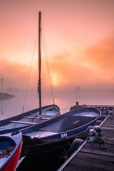 Foggy sunrise on the waterfront with small boats by Rick van de Kraats