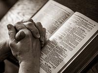 mains en prière au-dessus d'une Bible