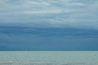weißes Segelboot unter den dunklen Wolken