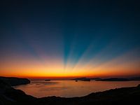 Magischer Sonnenuntergang mit strahlendem Himmel über ruhigem Meer