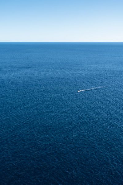 Un bateau et l'immensité bleue de la mer par Adriana Mueller