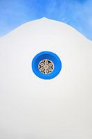 Blaues rundes Kirchenfenster in einer Kirche mit weißer Fassade in Portugal