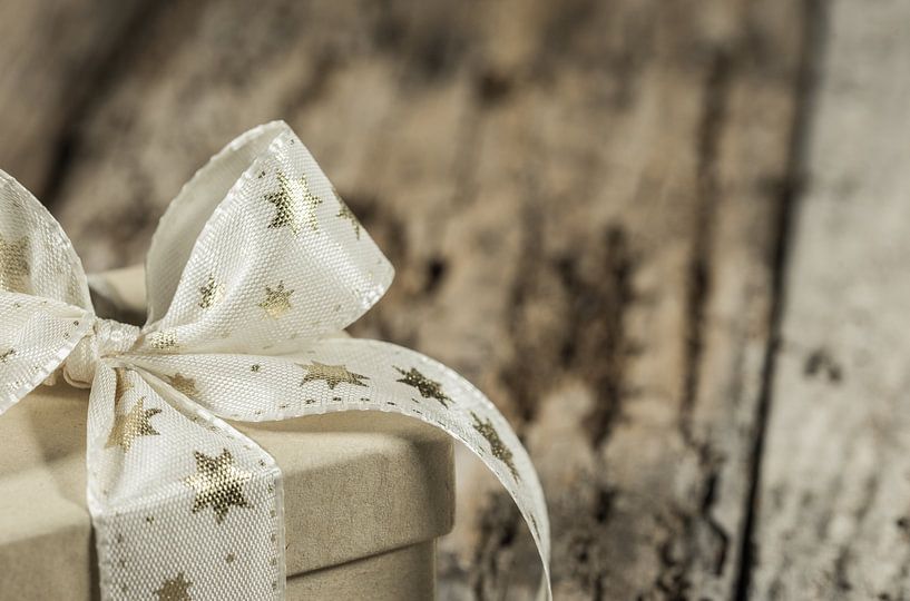 Nahaufnahme eines Weihnachtsgeschenks mit goldener sternförmiger Schleife von Alex Winter