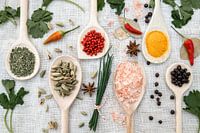 Spices and herbs on wooden spoons