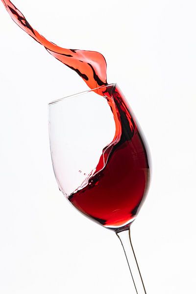 Red wine flows into the wine glass by Roland Brack