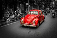 Volkswagen Käfer fährt die Straße hinunter.