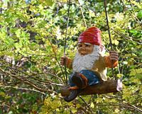 Gnom auf einer Schaukel.