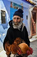 Old man with beard and chickens in Morocco