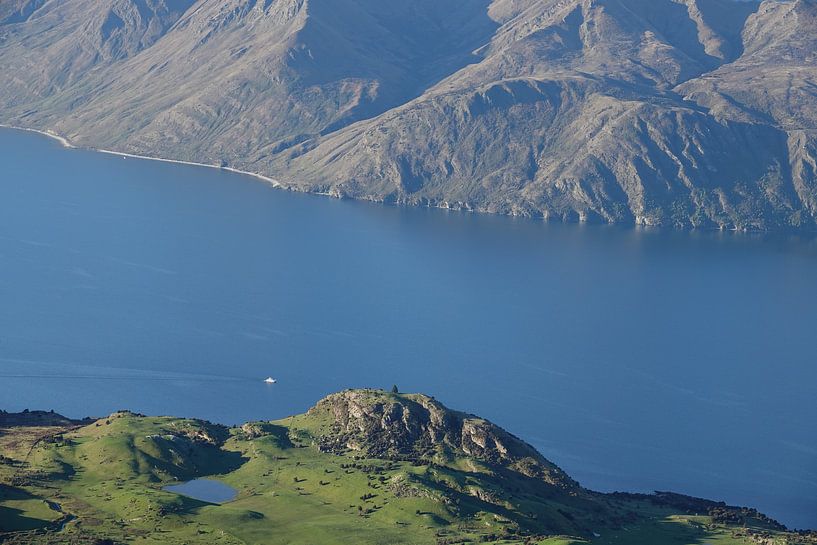 Petit bateau entre les murs de haute montagne sur le lac Wanaka en Nouvelle-Zélande par Aagje de Jong