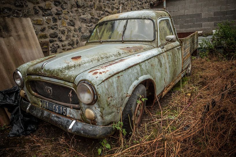 Vieux pick-up Peugeot bleu dans une grange dans un village en France par Joost Adriaanse