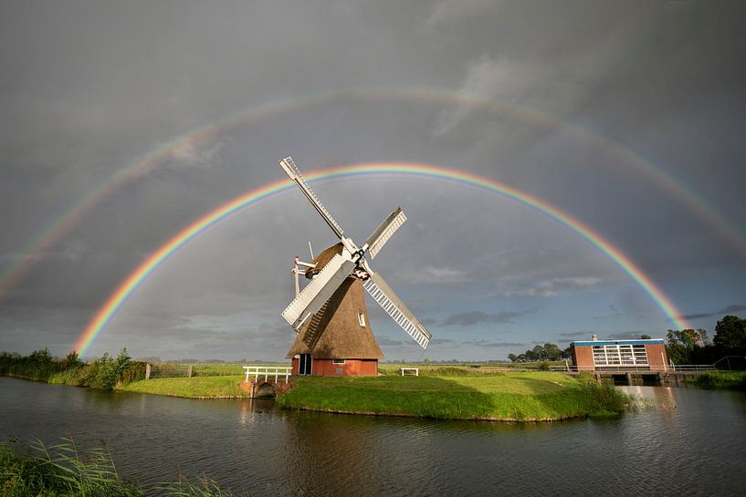 grand double arc-en-ciel au-dessus d'un moulin à vent néerlandais sous une pluie d'été par Olha Rohulya