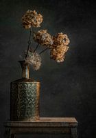 Still life with golden vase against a dark background