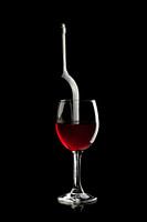 Elegant Wine Bottle and Red Wine Glass on a Black Background #2