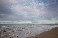 Reflecties op een nat strand bij zonsondergang