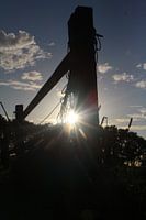 Paal in weiland met tegenlicht en avondzon