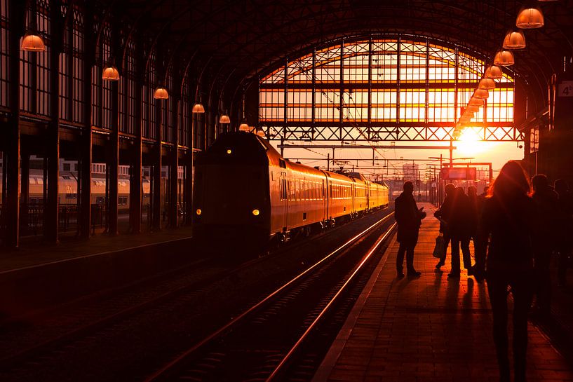 Waiting train travelers on platform at sunset by Rob Kints