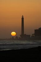 Ondergaande zon achter de vuurtoren van Maspalomas