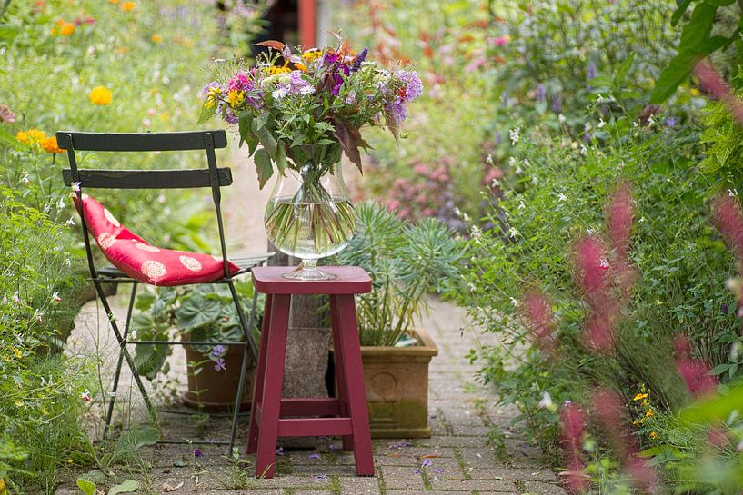 View through the summer garden with a vase of flowers by Birgitte Bergman