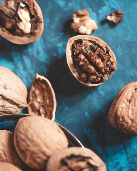 Zerbrochene Walnüsse auf einem blauen Tisch von butfirstsalt