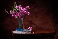 Still life of lathyrus in vase, with pearls and candle.