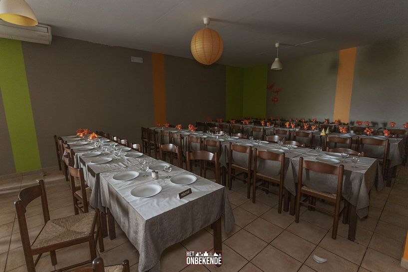 Covered tables in an abandoned restaurant. by Het Onbekende