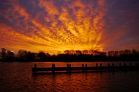 Zonsopkomst bij een steiger / Clouds lit up at sunrise.