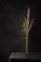 Dark still life with dried flowers on old wooden table
