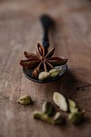 Kardamom und Sternanis auf schwarzem Löffel und Walnussholz
