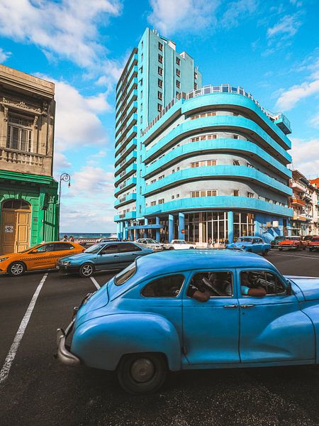 Cuban street corner in Havana with the bright blue BelleVue Deauville hotel in the background and a  by Michiel Dros