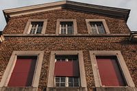 Rote Fensterläden eines verlassenen Schlosses