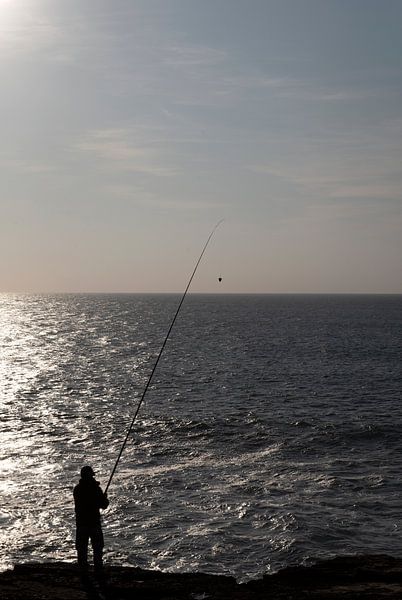 Pêcheur au bord de la mer au coucher du soleil par Margot van den Berg