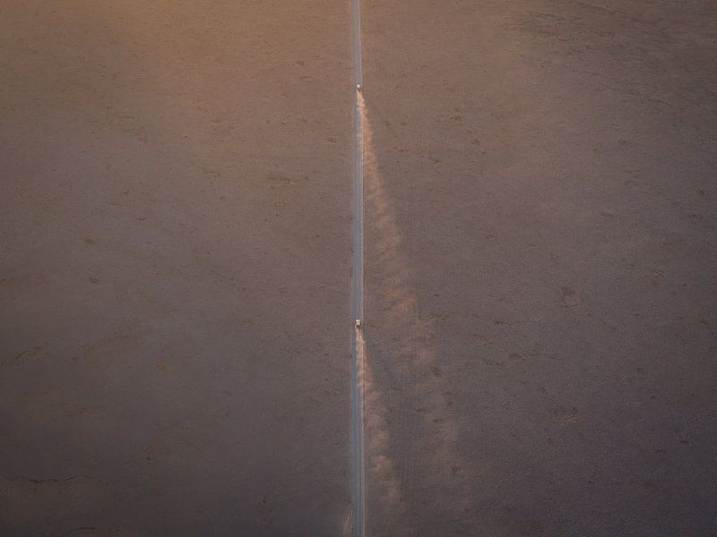 Photo minimaliste de voitures roulant sous le soleil du matin dans le désert de Sossusvlei | Photogr par Teun Janssen