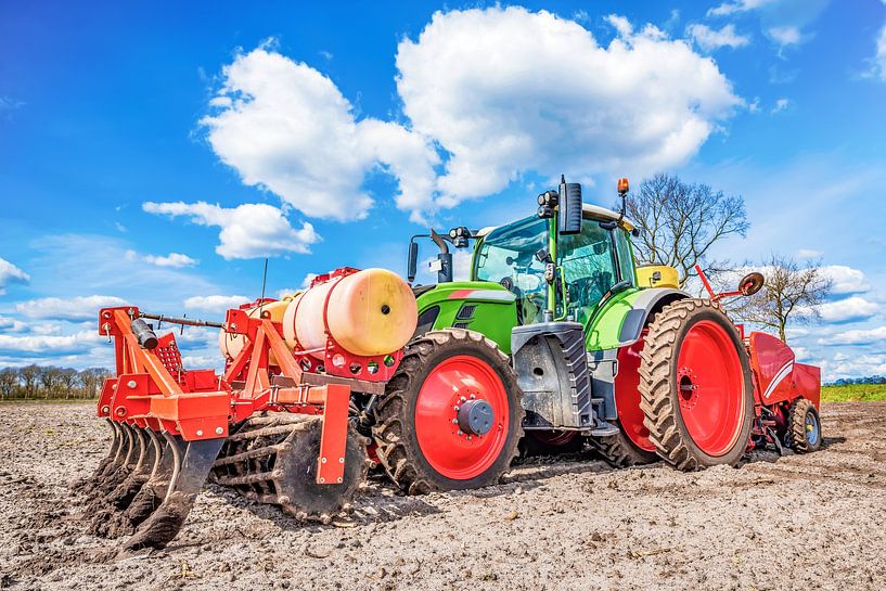 Green tractor sowing potatoes by Günter Albers