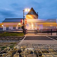 Cuijk train station with passing train in the evening