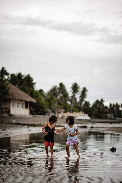 Children on the beach in fishing village in Philippines by Yvette Baur