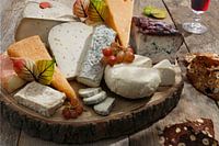 Plateau de fromages avec différents fromages sur une table en bois
