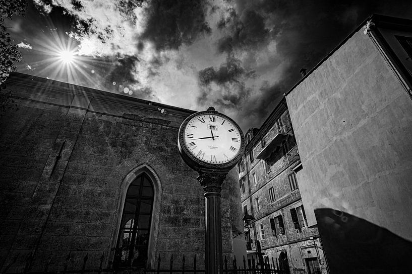 Schwarz-Weiß-Fotografie einer stehenden Uhr in einem italienischen Dorf. von Frans Scherpenisse