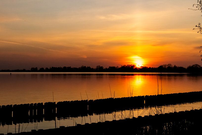 Red sunset by the water by Vincent den Hollander