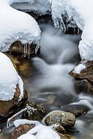 Fliessender Bach im Schnee