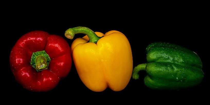 Macro verse paprika's met waterdruppels in kleuren rood geel groen tegen zwarte achtergrond van Dieter Walther