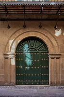 Door decorated with brass decorative hardware on Calle Major de Puente la Reina