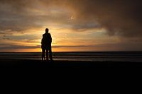 Romantische junge Paar bei Sonnenuntergang auf dem Wattenmeer