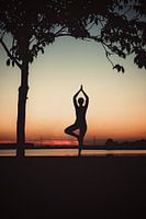 Yogapose comme silhouette au coucher du soleil