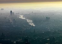 Gegenlichtfotografie des Zentrums von Amsterdam, wo ein Nebel über der Stadt liegt.