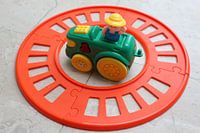 Spielzeugeisenbahn mit Zug neben dem Gleis